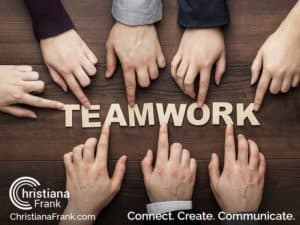 a group of people pointing their fingers at the word teamwork