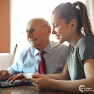 an older man and young woman using a laptop computer
